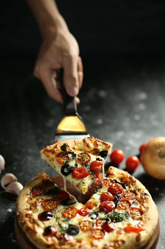 Photograph of a melting vegetarian pizza ready to be shared